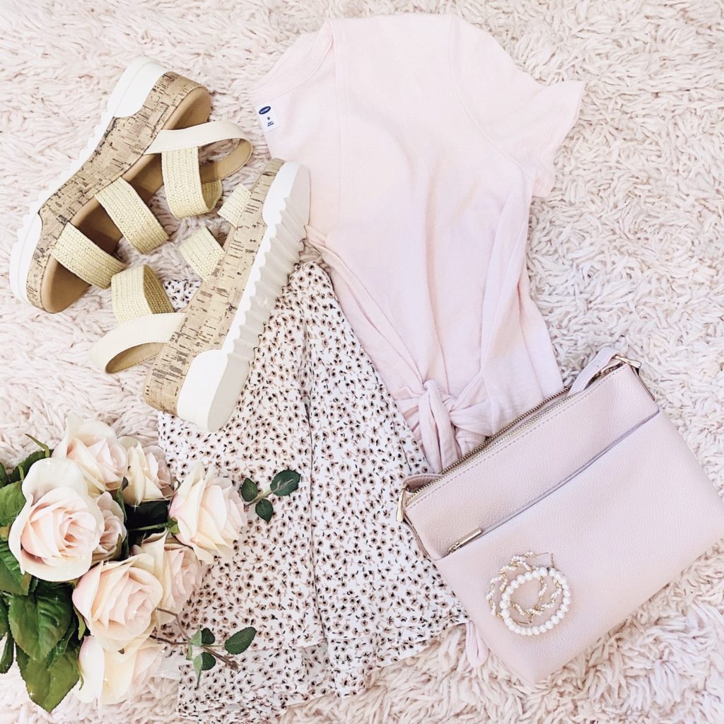 pink floral skirt outfit ideas, pink and white ditsy floral skirt styled with a pink v-neck wrap top, straw steve madden espadrille dupes, a pearl bracelet, pearl hoops, pink purse, and gold rings