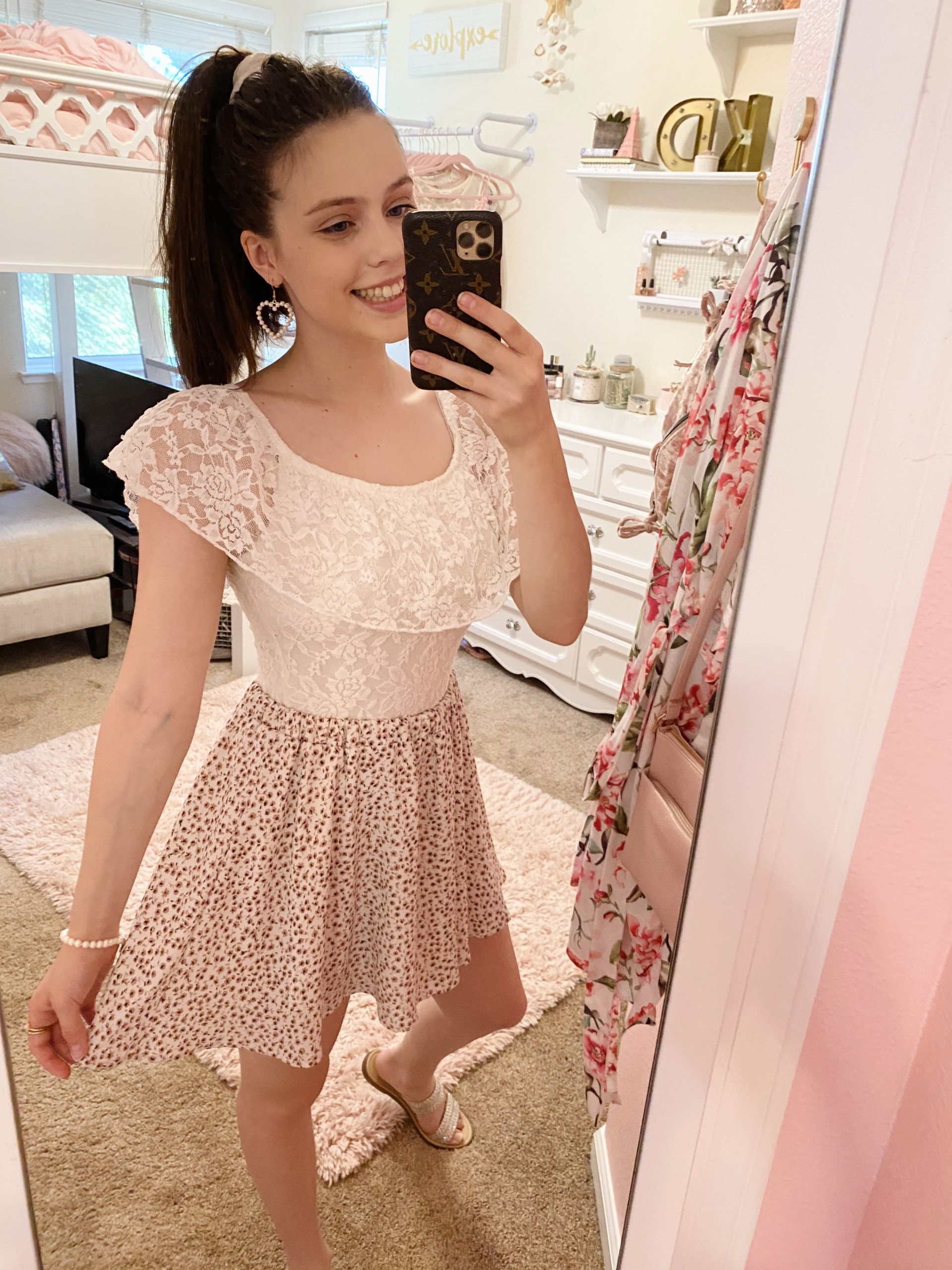 floral skirt outfit ideas, pink and white ditsy floral skirt with white lace top, pearl heart earrings, a pearl bracelet, taupe kersha embellished sandals, and a white scrunchie in a high ponytail