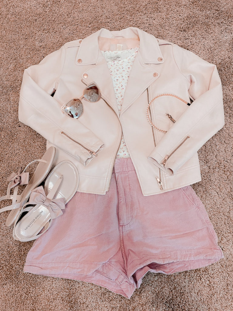 pink pleather jacket with pink shorts, pink bow, ted baker sandal dupes, a white floral tee shirt with pink cat eye sunglasses, and a pearl headband